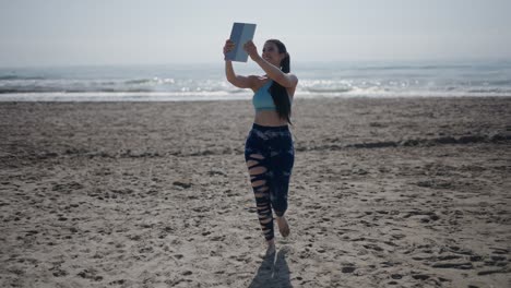 woman taking a selfie on a beach while exercising