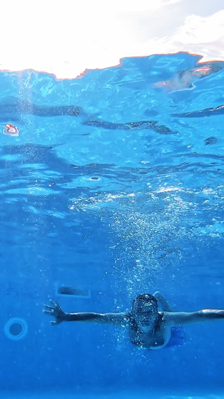 Underwater fun. Handsome young man swimming in pool. Sport and leisure. Vertical video