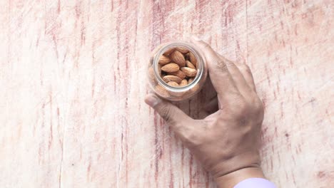Hand holding a jar of almonds