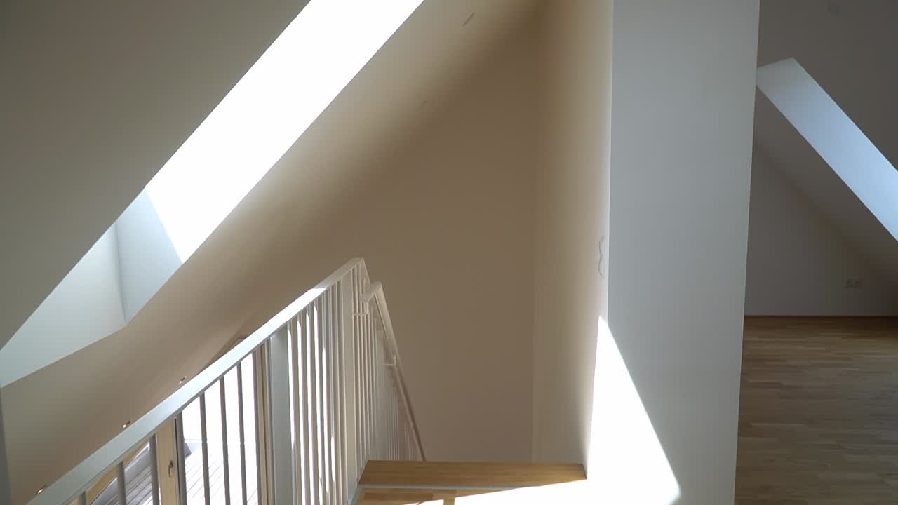 Walking down the stairway to the living room in an empty apartment for sale.