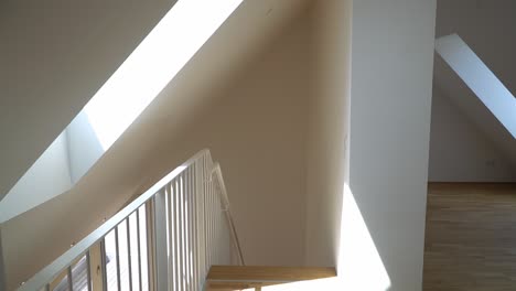 walking down the stairway to the living room in an empty apartment for sale.