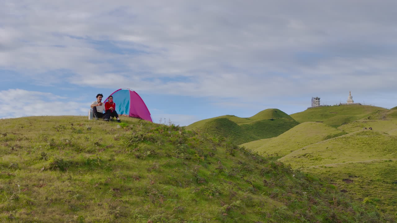 드론 촬영은 네팔 도라카의 세일룬 언덕에서 캠핑하는 만적인 커플을 포착합니다.