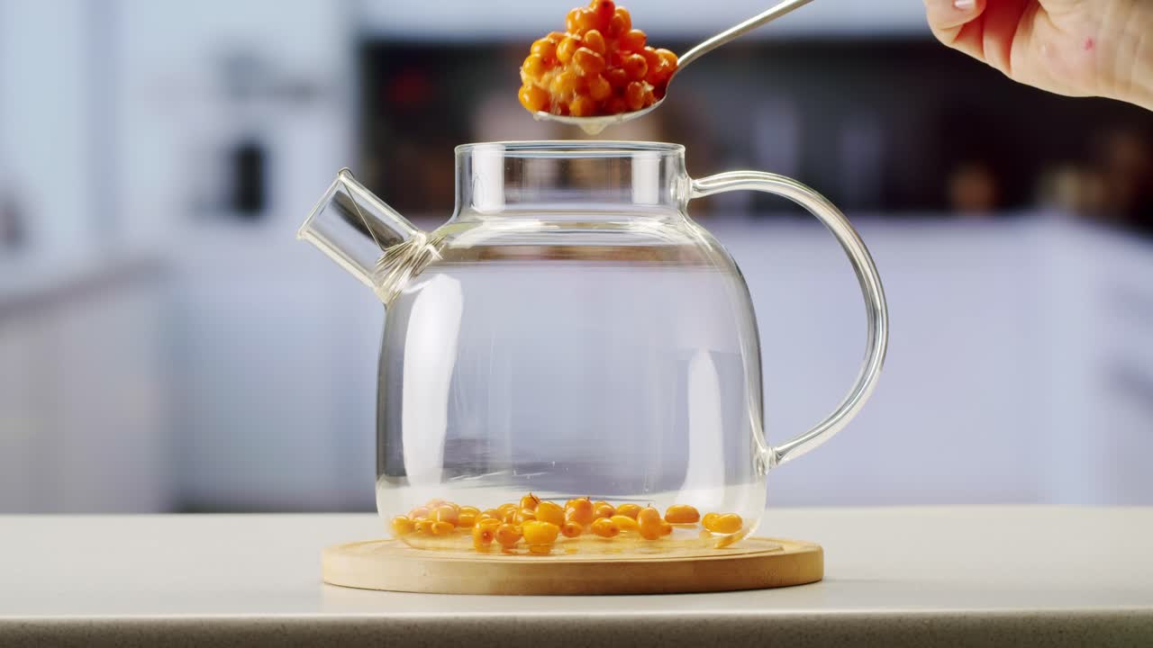 해바라기 건강한 베리 차 음료, 유리 항아리 및 잎을 가진 가지에 얼어붙은 익은 베리 어두운 나무 농촌 배경에  뷰, 피부, 심장, 혈관 및 면역 체계에 훌륭합니다.