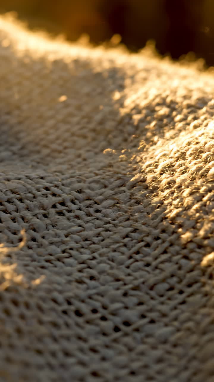 Detail texturované tkané látky osvětlené zlatým sluncem