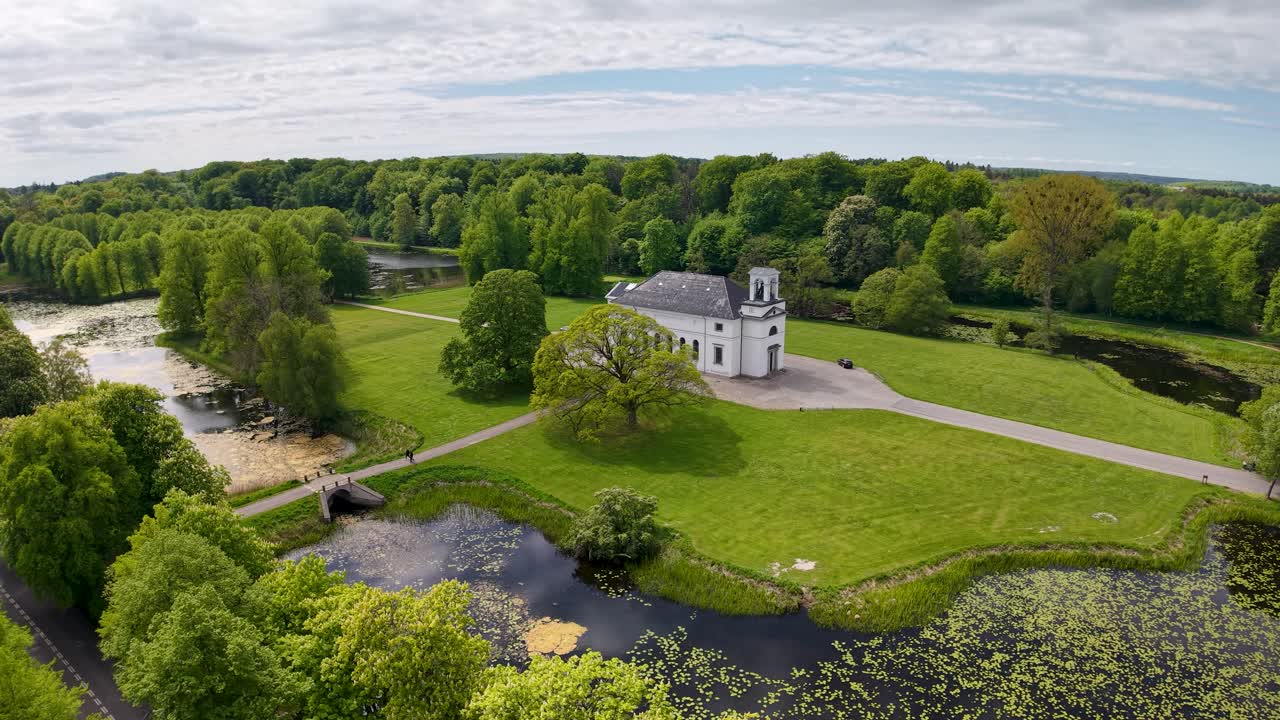 Ilmakuva pienestä veneestä risteilemässä aaltoilevalla vedellä puolipilvisen taivaan alla lähellä rantaviivaa