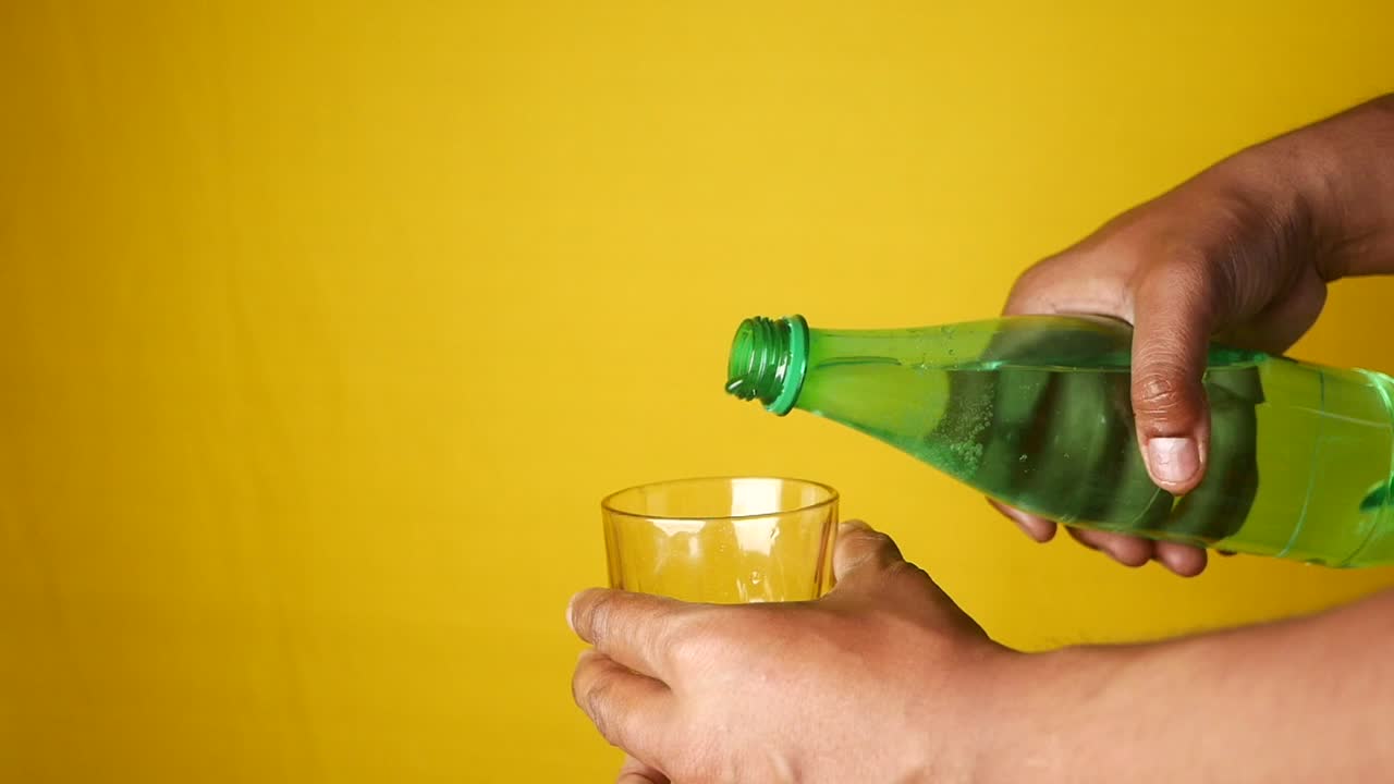 vertiendo agua de una botella en un vaso