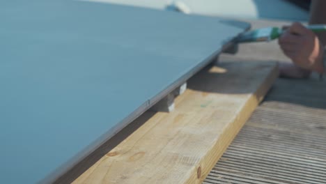 painting edge grain of wooden boat plywood engine cover hatch, medium close up