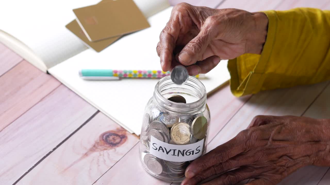 Elderly Woman Saving Money in a Jar