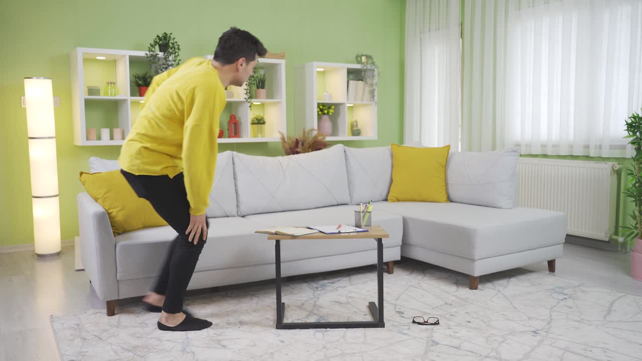 어색하고 불행한 젊은이가 테이블에 발을 부 ⁇ 히고 다리를 다치게 합니다.