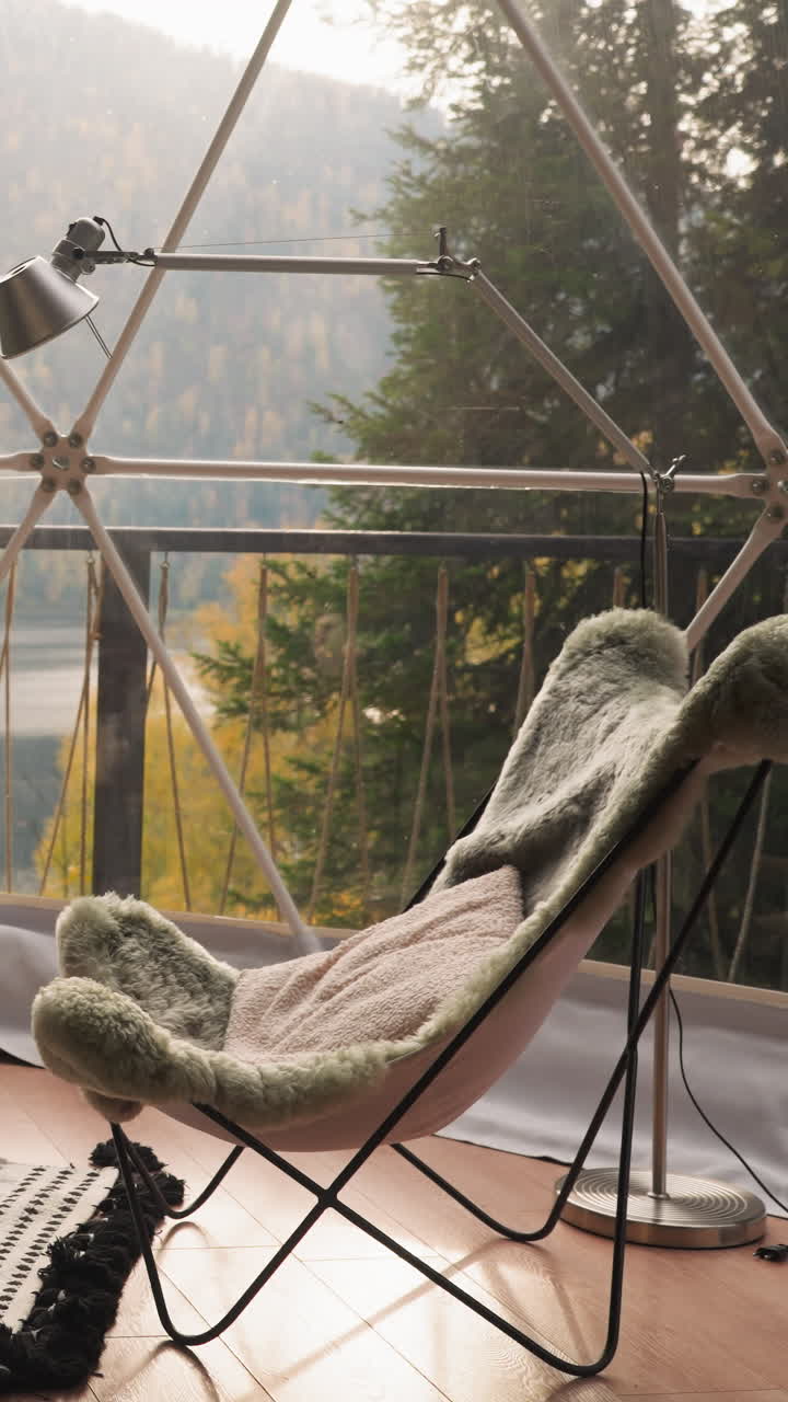 terraza de vidrio con mesa de café y sillones. balcón panorámico de casa de glamping con muebles acogedores para las pausas de almuerzo para disfrutar de impresionantes vistas del lago y el bosque