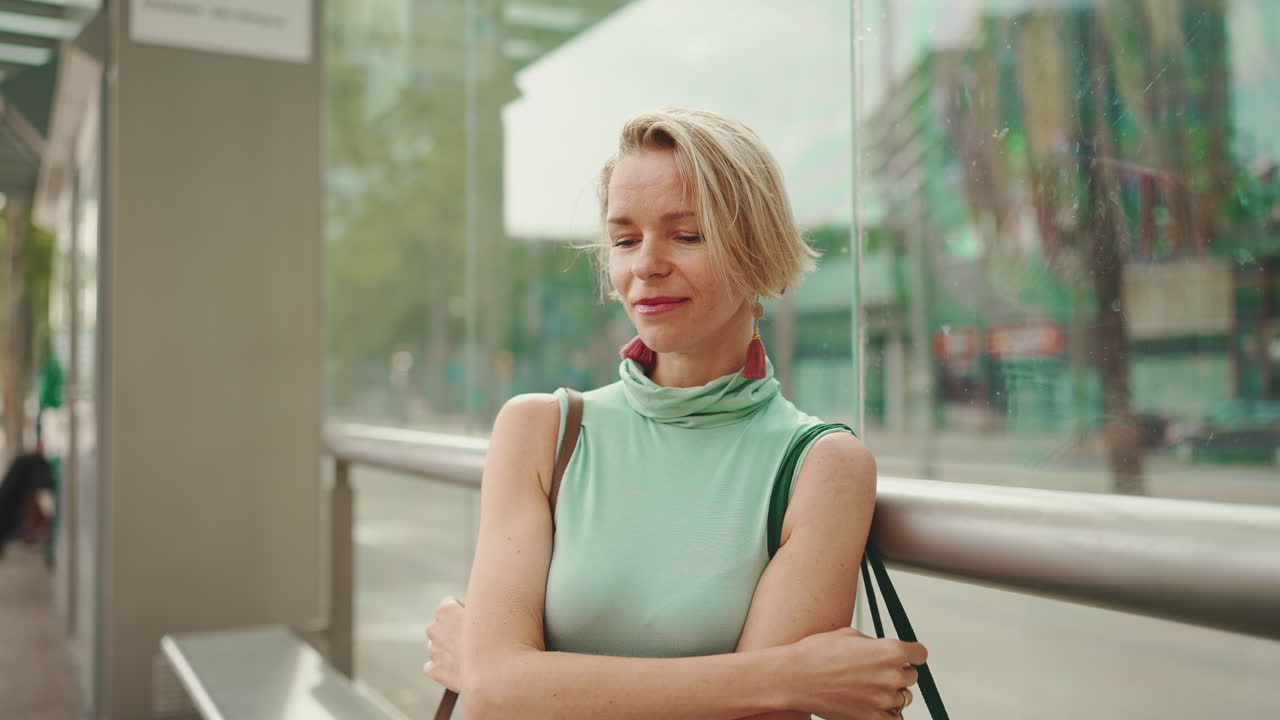 Kvinde, der venter på et busstoppested