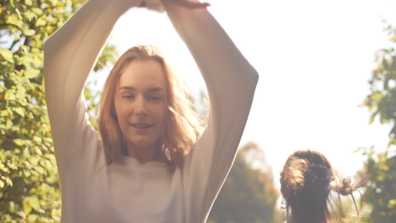 두 명의 젊은 여성들이 공원에서 이 좋은 날을 즐기고 있습니다.