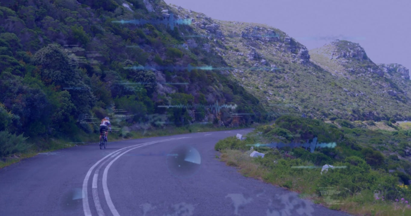 Ciclista donna che pedala su una strada collinare tortuosa, il movimento causa sovrapposizioni tecnologiche blu che mostrano metriche