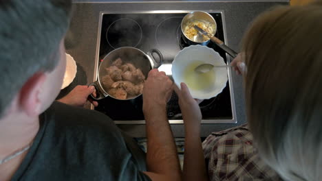 Couple-cooking-together-meat-and-sauce