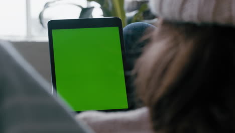 mujer usando una tableta digital viendo la pantalla verde relajándose en casa en el sofá disfrutando del entretenimiento en línea