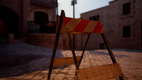 a red and white striped construction barricade in front of a stone building