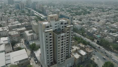 Luftdrohnenaufnahme-Eines-Hochhauses-Und-Belebter-Stadtstraßen-In-Karatschi,-Pakistan