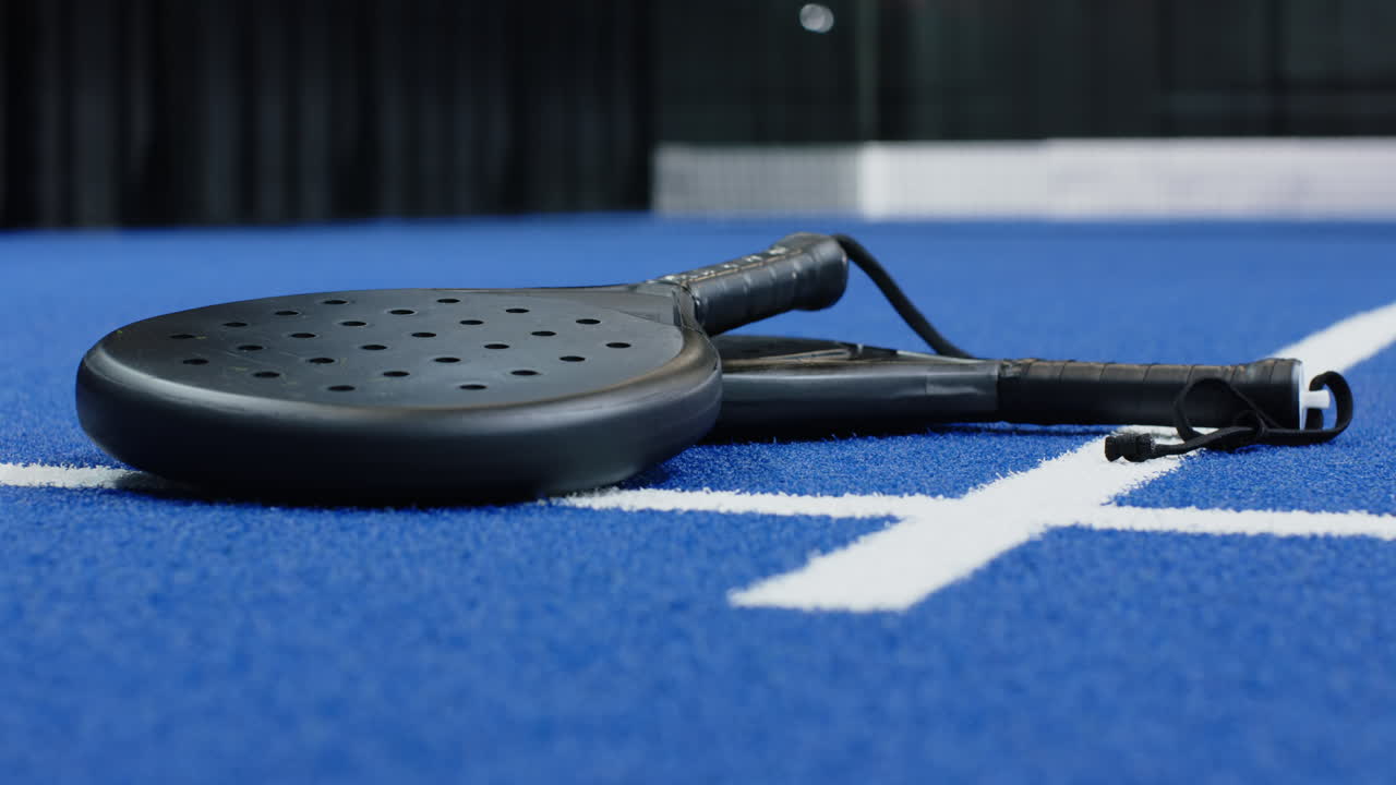 Padel racket resting on blue court, ready for exciting match, copy space