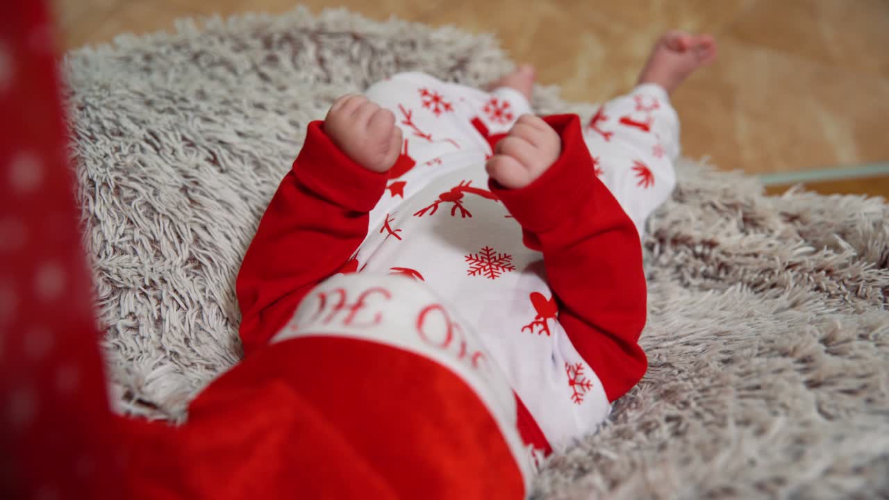 un bebé en un capó de año nuevo con un sombrero de año nuevo en la cabeza yace en un dosel de madera