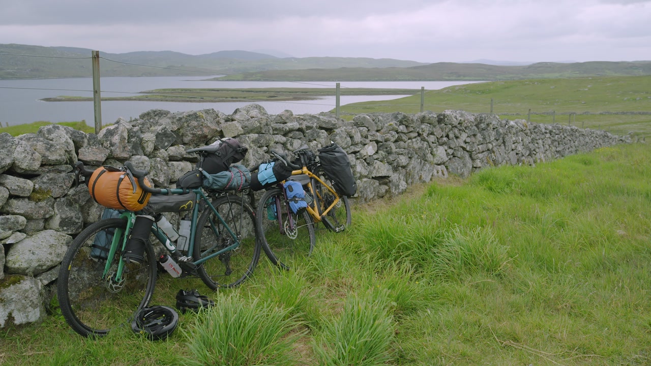 Static shot of two bicycles leaning against a traditional stone wall on Lewis.