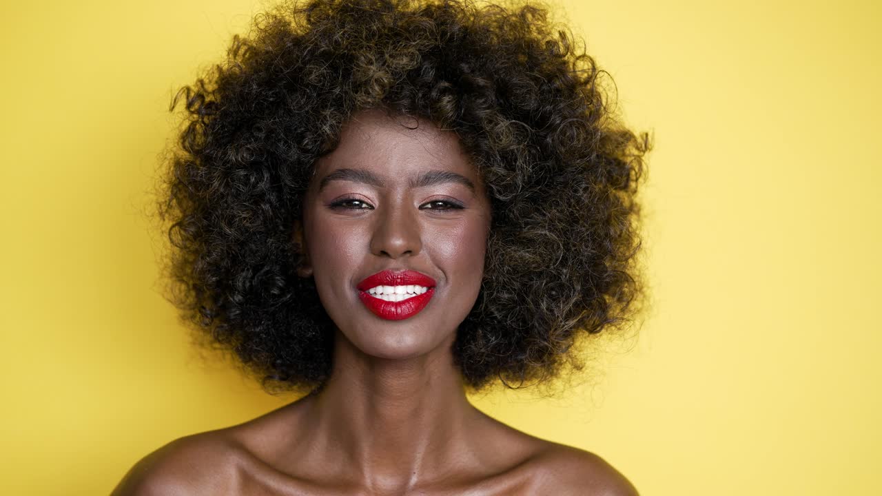 retrato de una mujer sonriente con el cabello rizado
