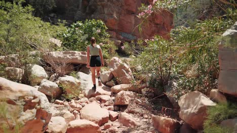 Young-caucasian-woman-walking-through-a-valley-in-Paradise-Valley,-Agadir,-Morocco