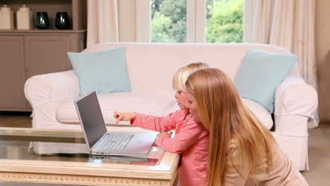 cute little girl using laptop with mother