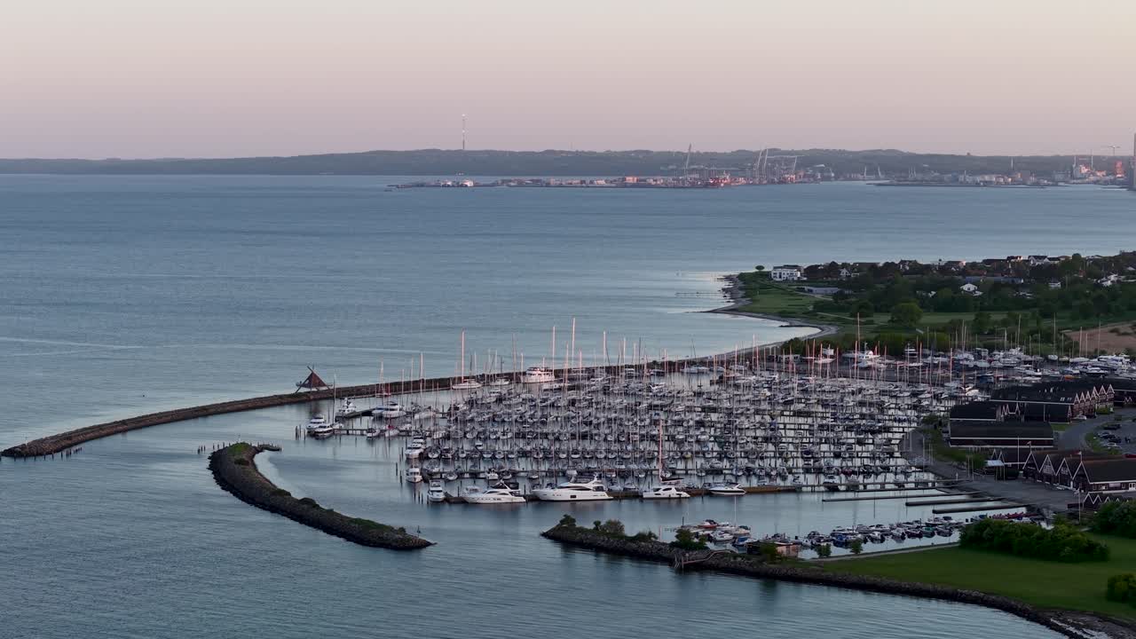 Marina full of docked boats along the coastline at dusk in Denmark