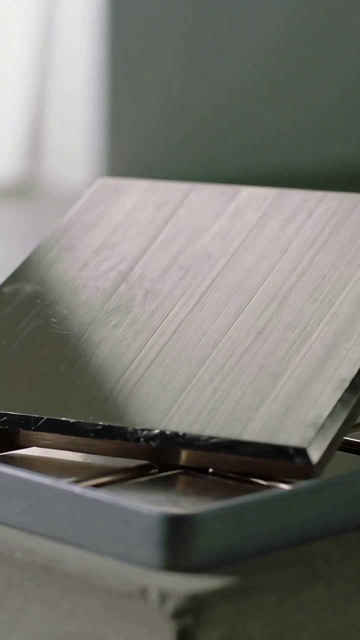Vertical video: Tilting on hinge release, metal griddle covering gas burner on range, showing scuff
