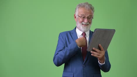 hombre de negocios barbudo y guapo contra un fondo verde.