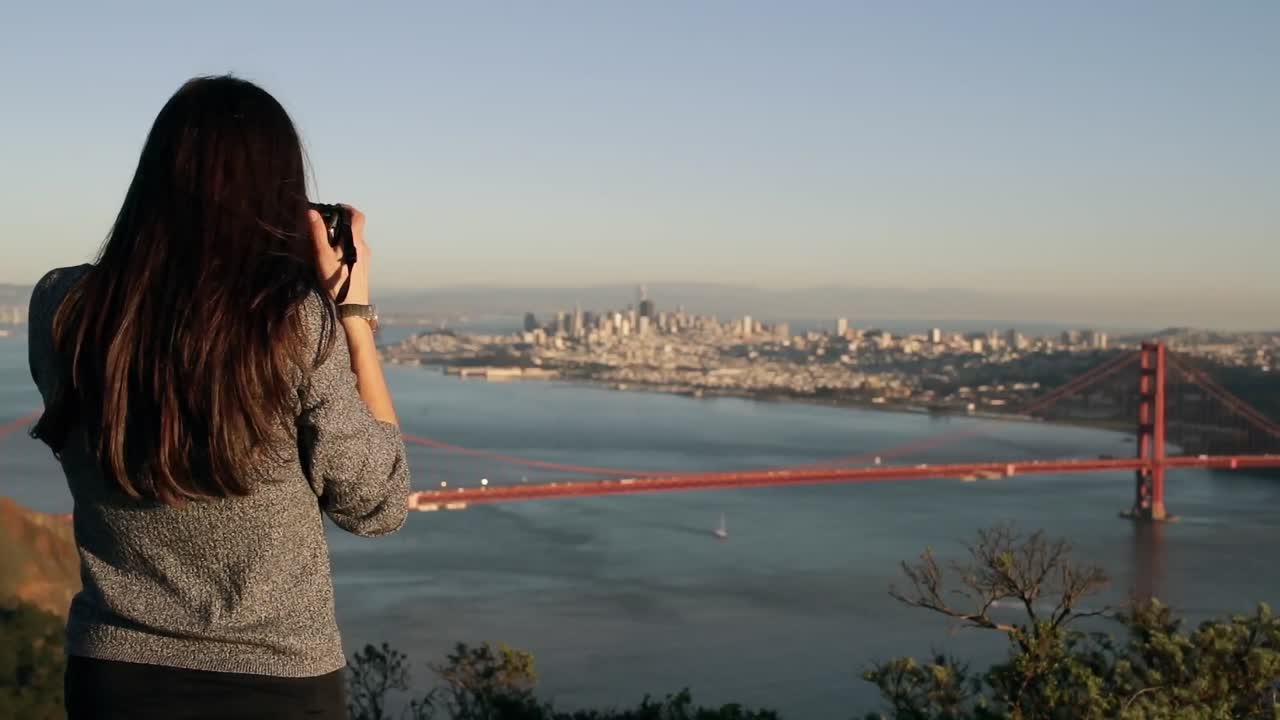 mujer fotografiando el puente golden gate, san francisco
