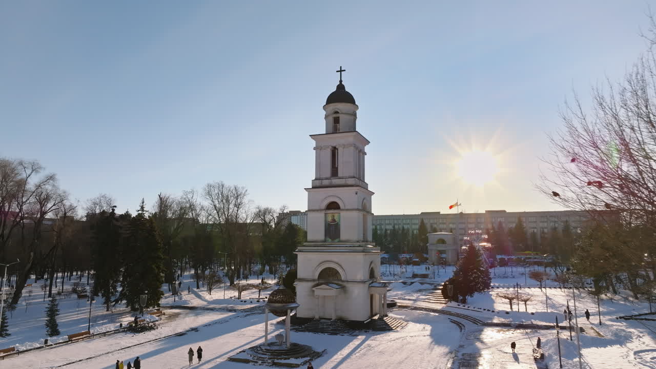 Aerial drone view of the Bell tower of the Metropolitan Cathedral of Christ's Nativity. City center covered in snow at sunset in Chisinau, Moldova