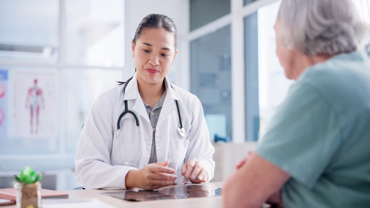 高齢者女性または医師が患者に相談している