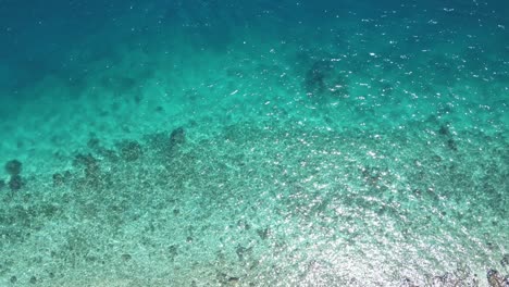 Vista-Aérea-De-Arriba-Hacia-Abajo,-Agua-De-Mar-Tropical-Cristalina,-Isla-De-Komodo,-Tiro-De-Drones-De-ángulo-Alto-De-Indonesia