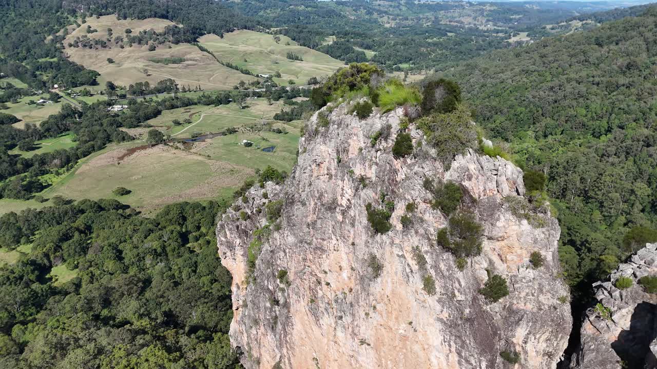 Drone footage captures the majestic rhyolite volcanic plugs surrounded by lush eucalyptus forests in rural Australia