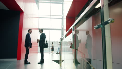 business people talking in modern office lobby