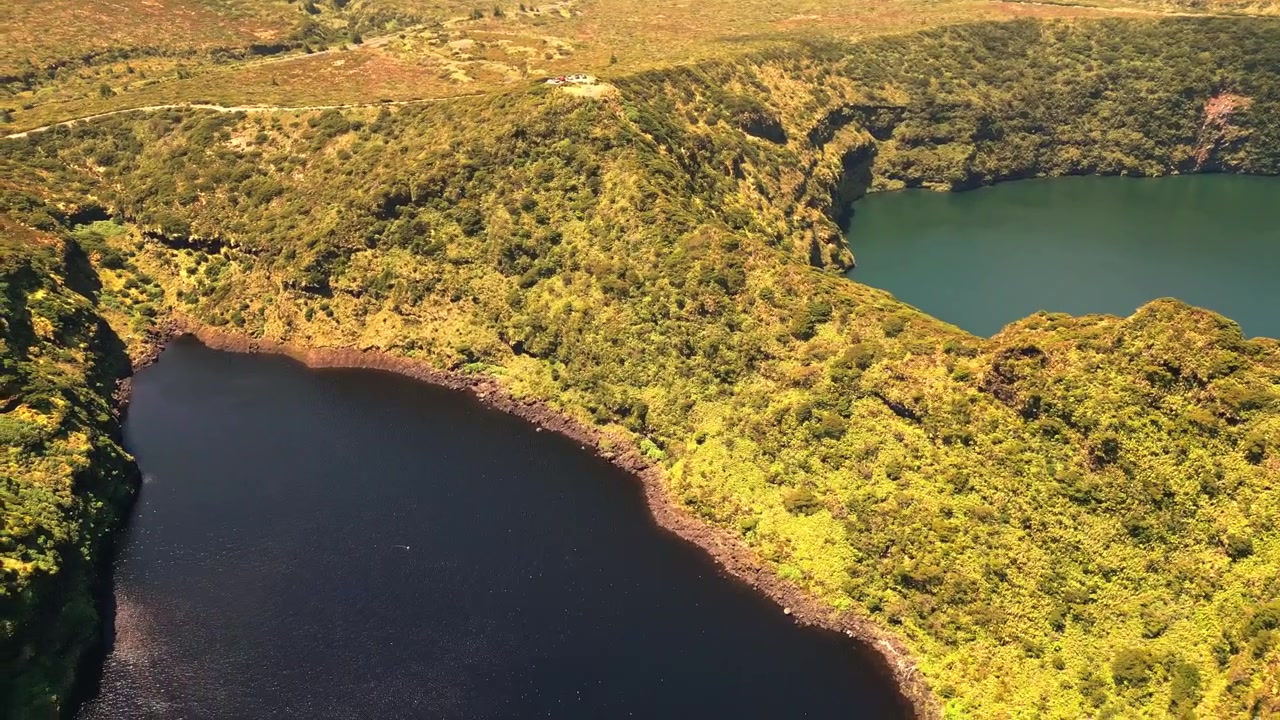 Vista aerea di due laghi vulcanici separati da un crinale verde lussureggiante sull'isola di Flores, Portogallo.