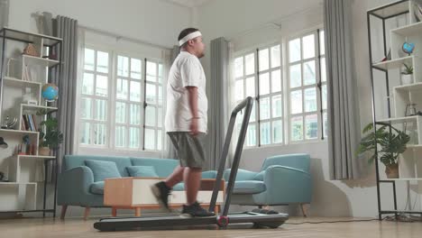 overweight man walking on a treadmill at home