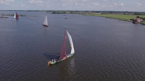 Drone-view-of-classic-sailing-boat-floating-on-calm-lake-at-Friesland