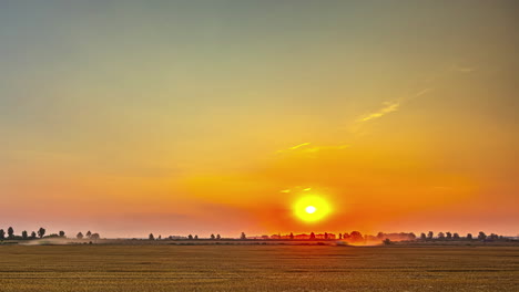 Colorful-Sunset-Sky-Over-Agricultural-Fields-With-Working-Farm-Tractor