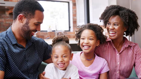 smiling family relaxing on sofa at home together