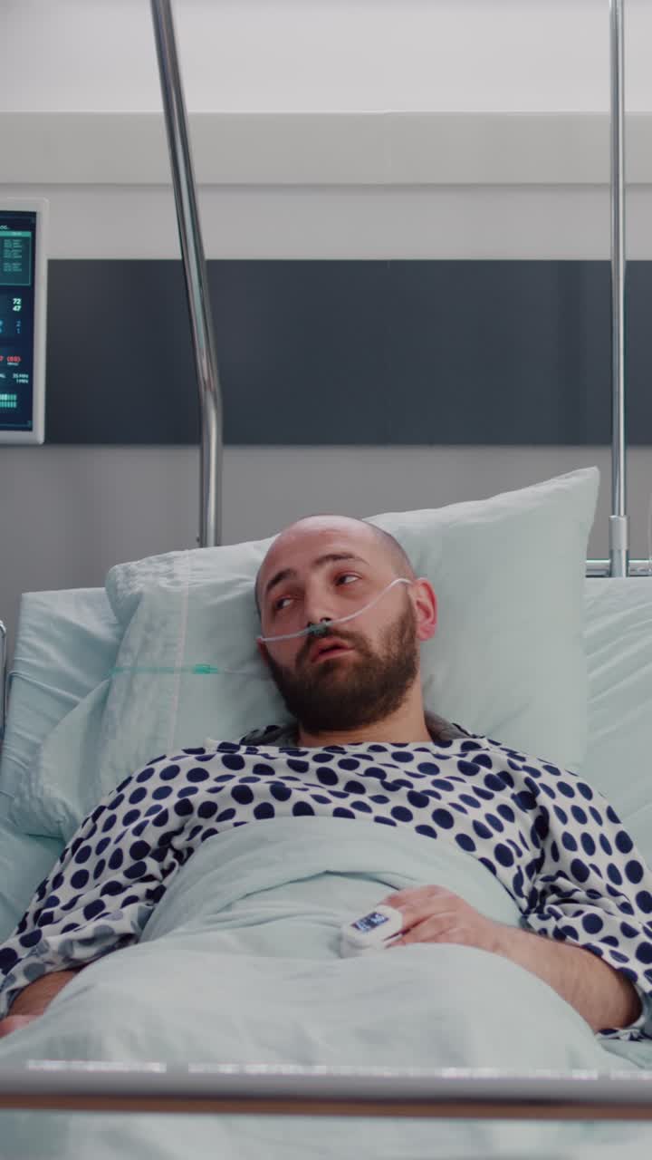 Vertical video: Practitioner nurse monitoring patient during sickness recovery writing disease symptom