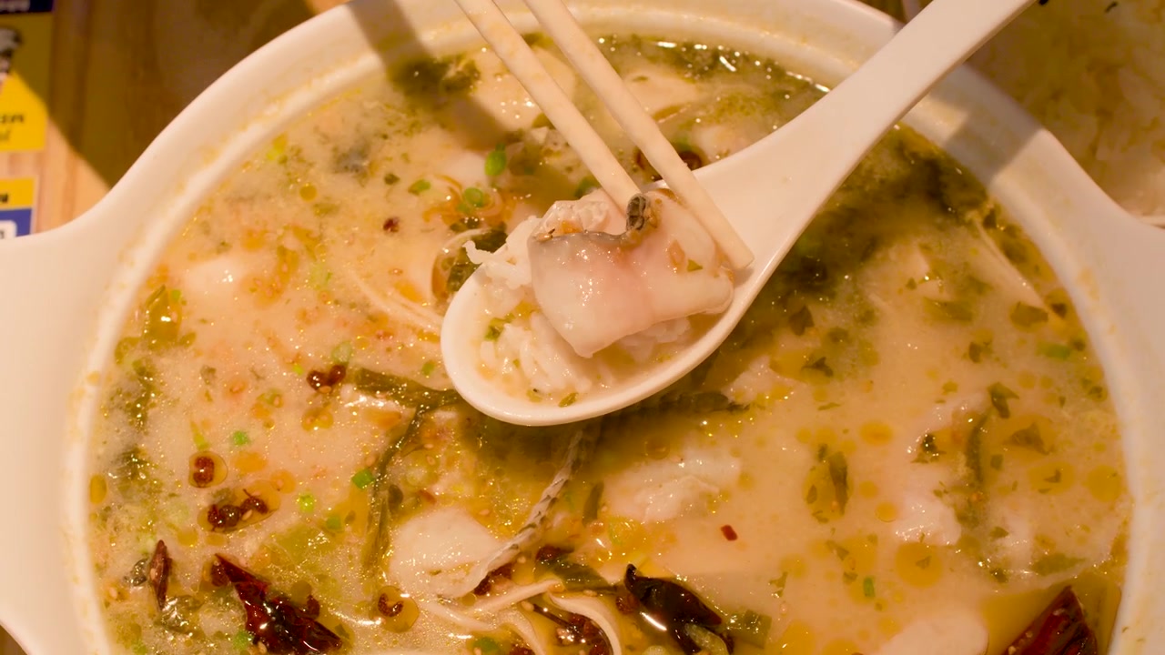 Spiser krydret fiskesuppe med ris på en restaurant
