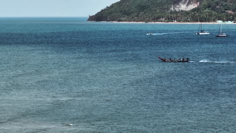 Toma-De-Seguimiento-Amplia-De-Un-Solo-Barco-Que-Sale-Hacia-El-Mar-Desde-La-Costa-Tailandesa