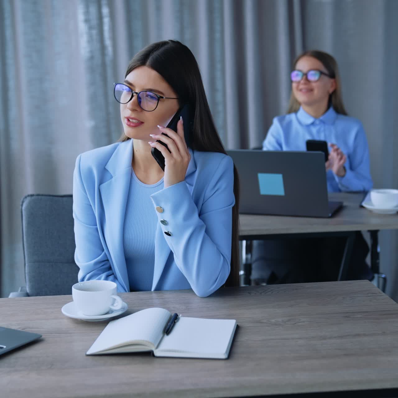 Successful young lady smartphone talking. Business phone call in modern office