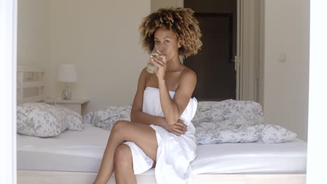 chica bebiendo agua fresca en la cama