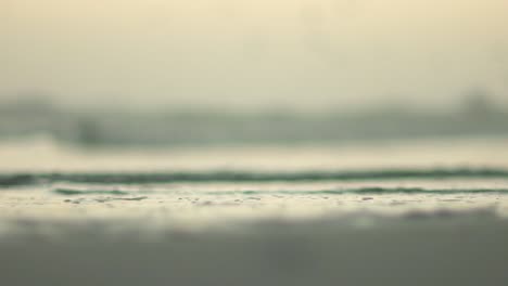 shallow depth of field shot of stones on beach as ocean water runs over them