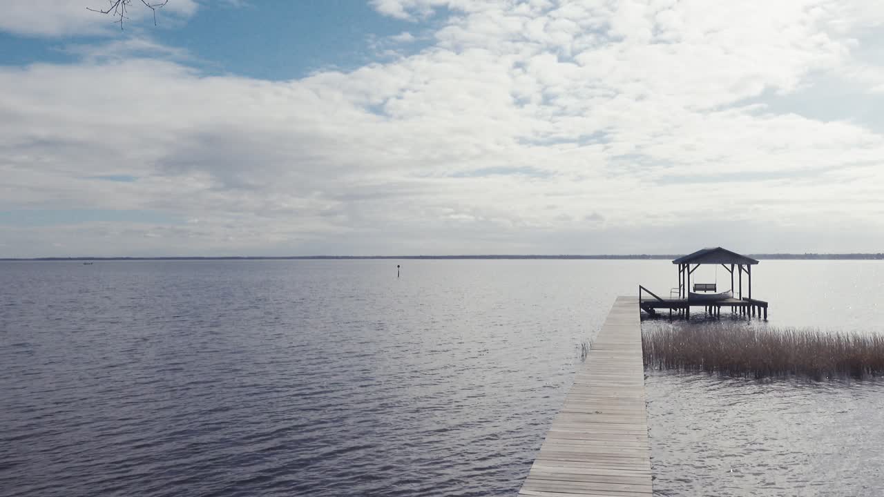 vista al final de la tarde a través del lago waccamaw con muelle y reflejos brillantes de nubes