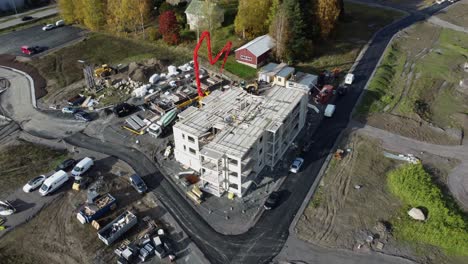 workers use heavy pump boom to get concrete into construction building