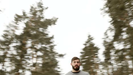 bearded man adjusts himself for a run along the winter road